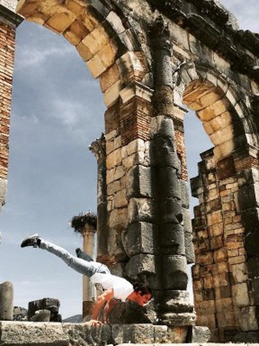 Matteo durante un esercizio di calisthenics tra le antiche rovine di Volubilis, Marocco