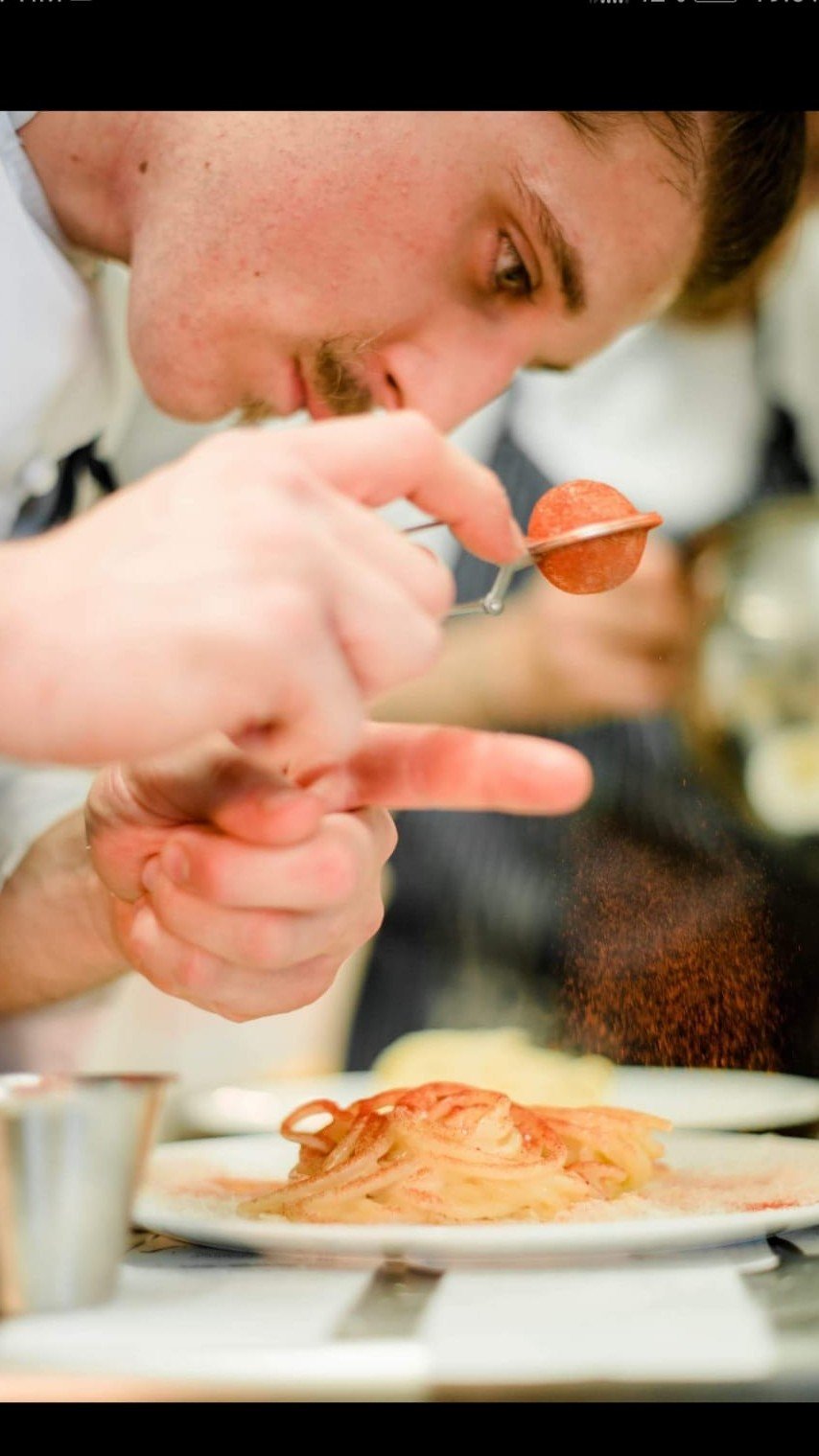 Preparazione di un piatto con paprika e spezie in cucina professionale
